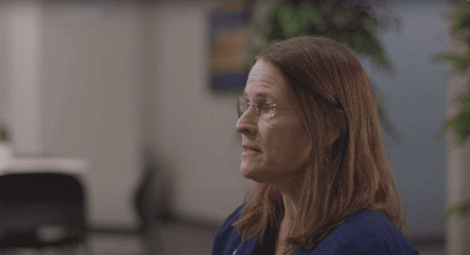 there is a woman with glasses standing in an office