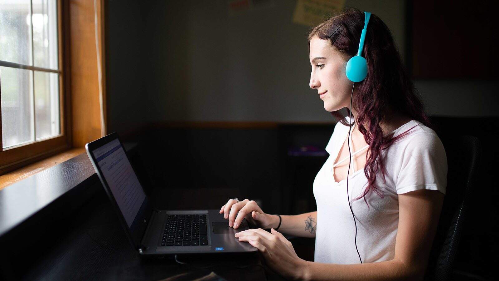 Teenager works at her laptop inside the Teen Drug Rehab at Cascade, Colorado.