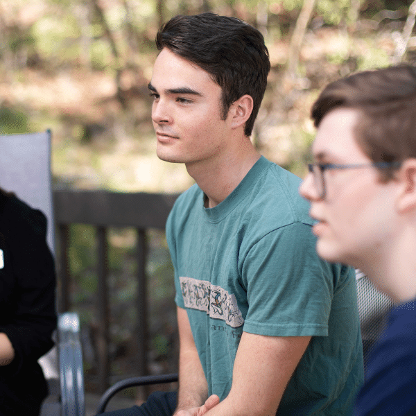 there are two people sitting on a bench talking to each other