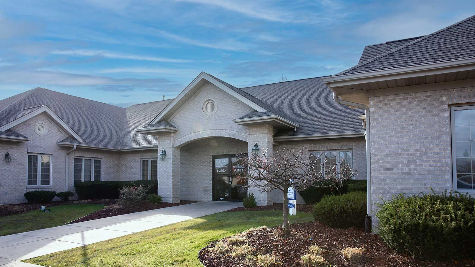 there is a house with a driveway and a sign in front of it