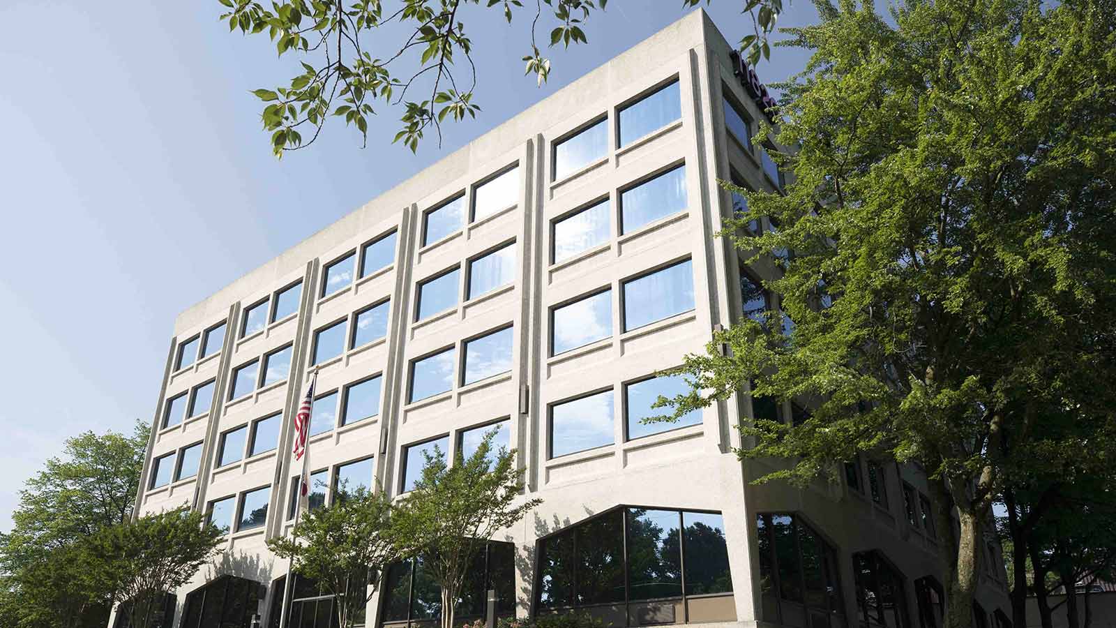 trees are in front of a building with many windows
