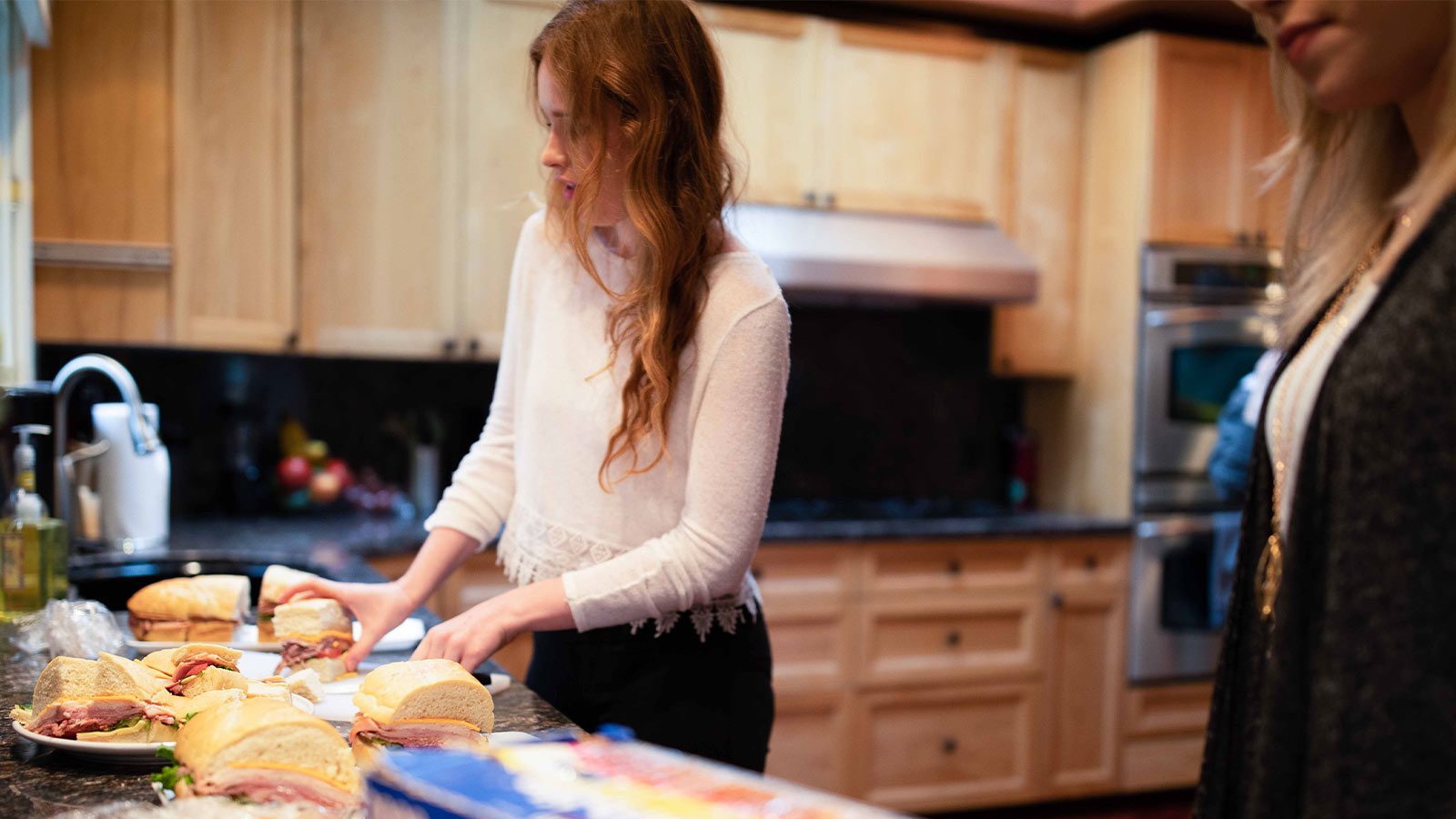 there is a woman standing in a kitchen preparing food on a counter