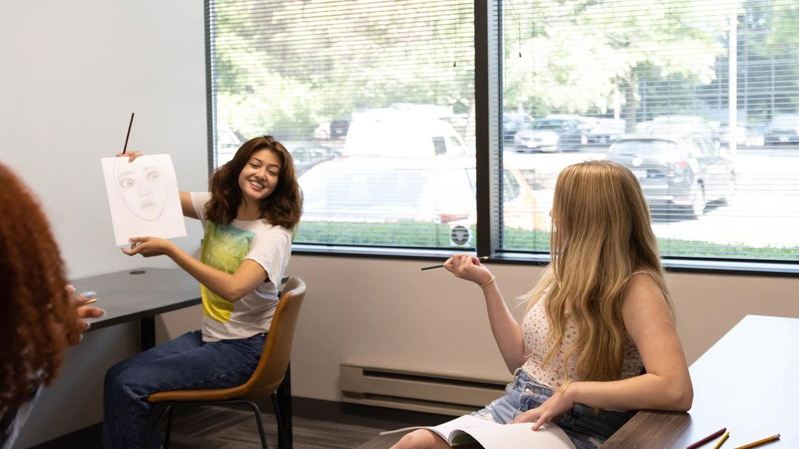 there are two women sitting at a table with a drawing on it