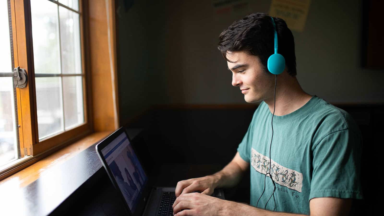 Teen in Sandstone Care program using laptop for virtual therapy and recovery support