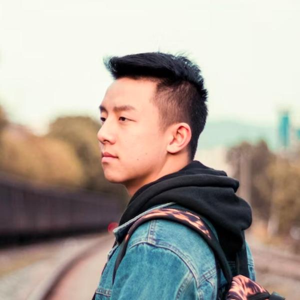 there is a man with a backpack standing on a train track