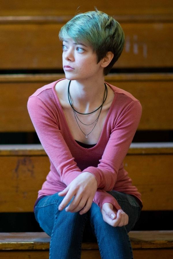 arafed woman sitting on a bench with a pink shirt and necklace