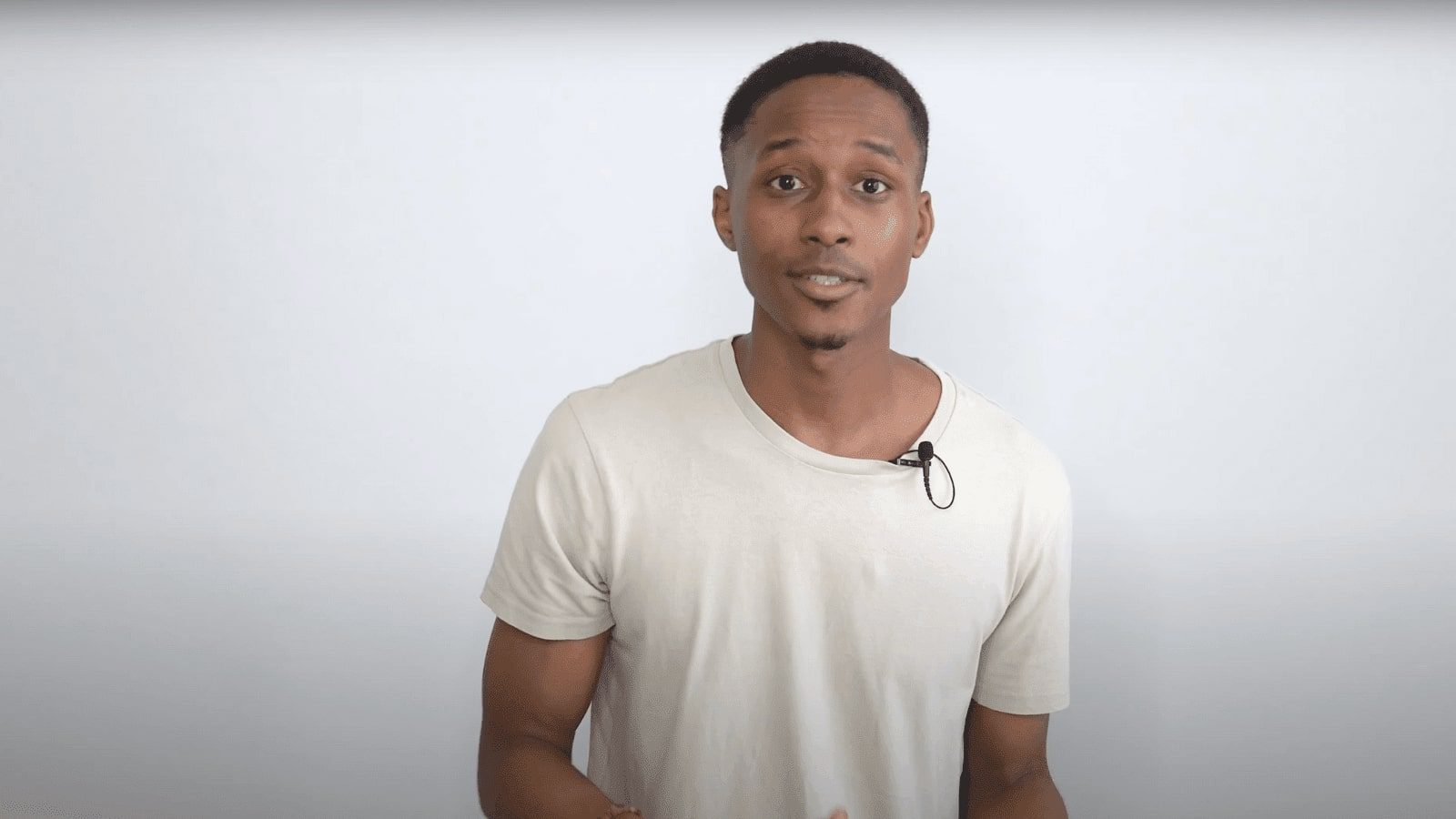 arafed man in white shirt holding a black object in front of him