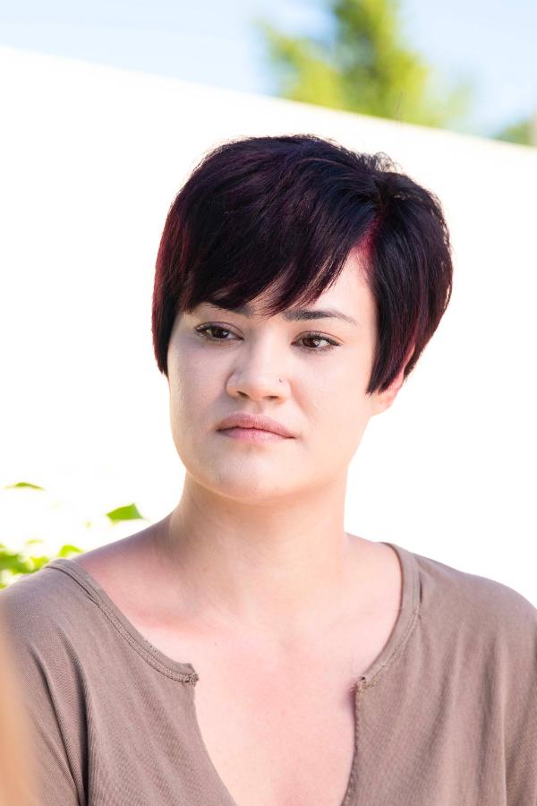 there is a woman with a short haircut and a brown shirt