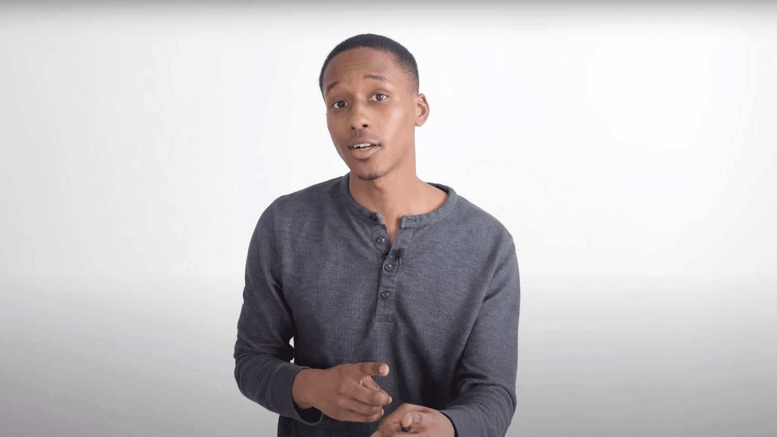 arafed man in a gray shirt is holding a cell phone