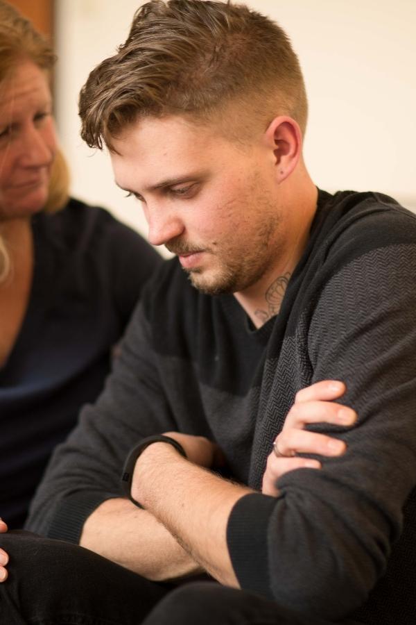 there is a man sitting next to a woman on a couch