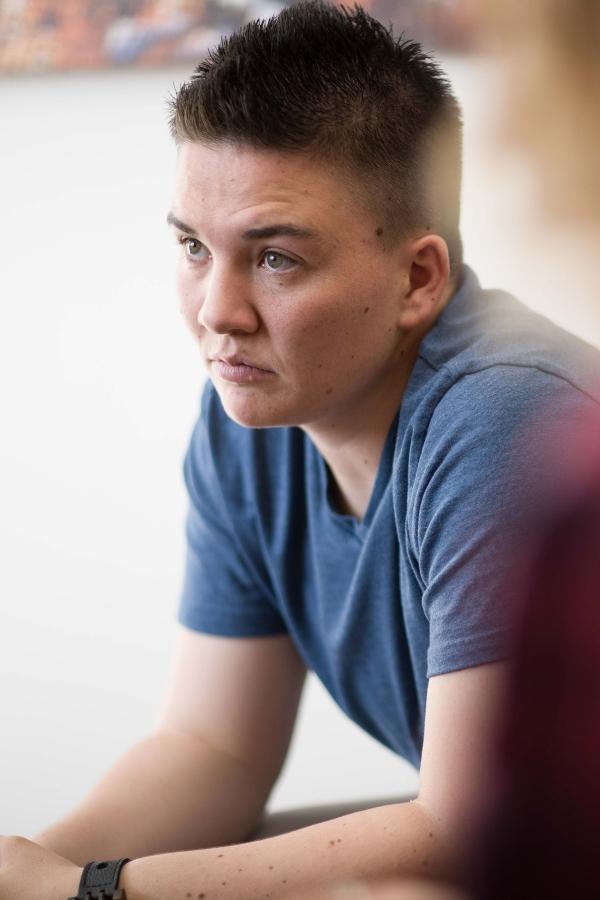 there is a man sitting at a table with a remote in his hand