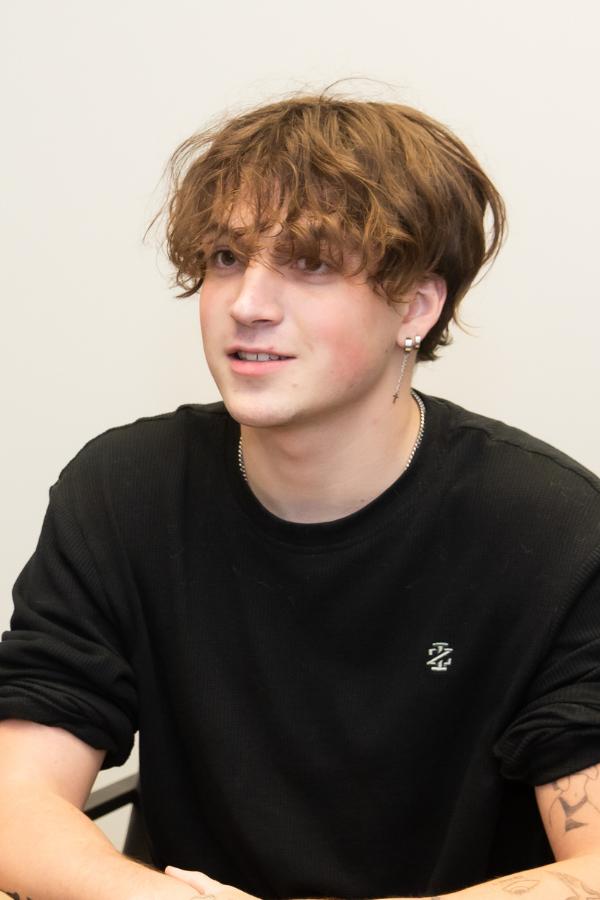 arafed young man sitting at a table with a remote control