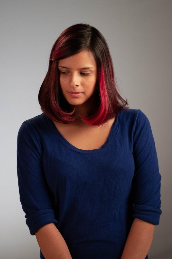 arafed woman with red hair cutting a cake with a knife