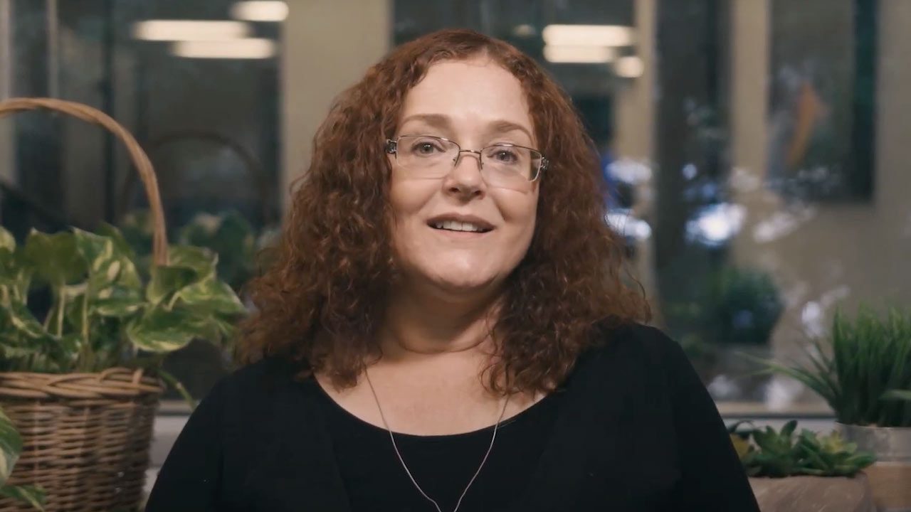a close up of a woman with glasses and a necklace