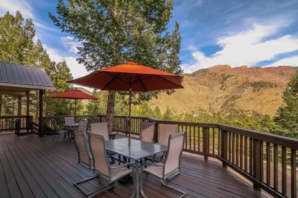 a close up of a table and chairs on a deck with an umbrella