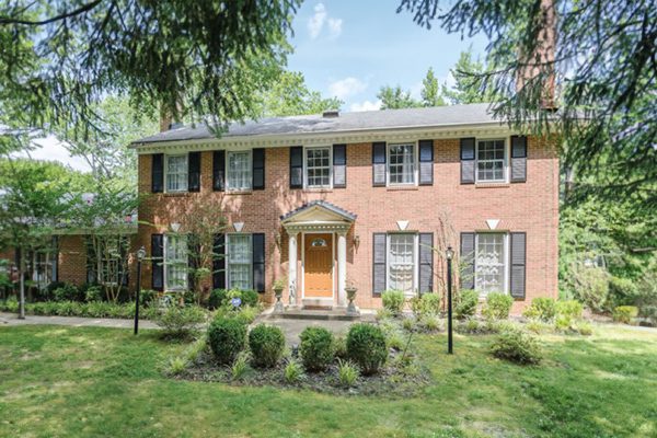 a brick house with a red door and green grass