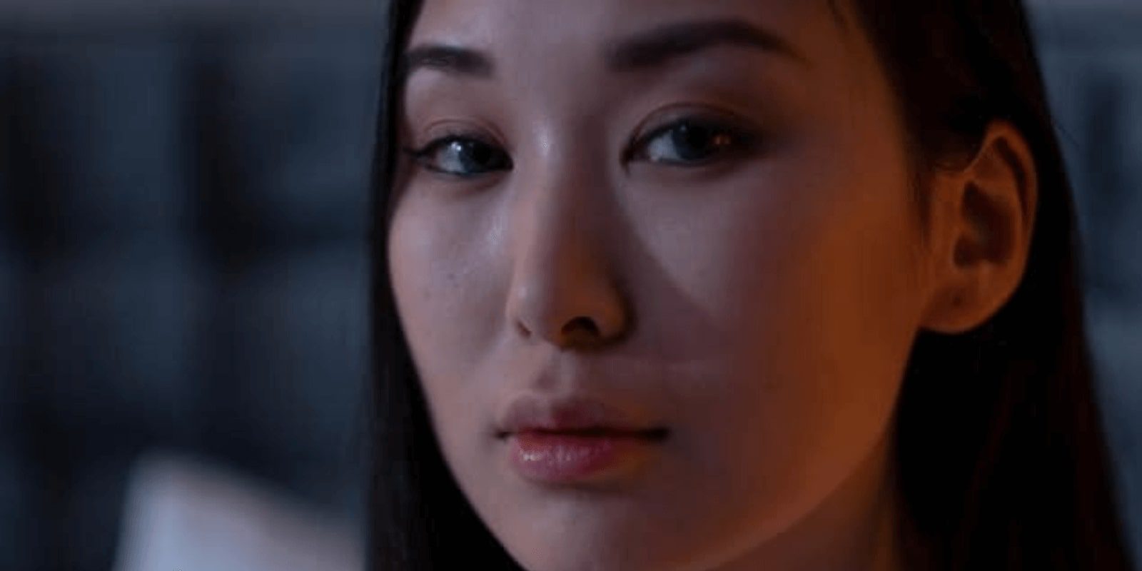 a close up of a woman with long hair looking at the camera