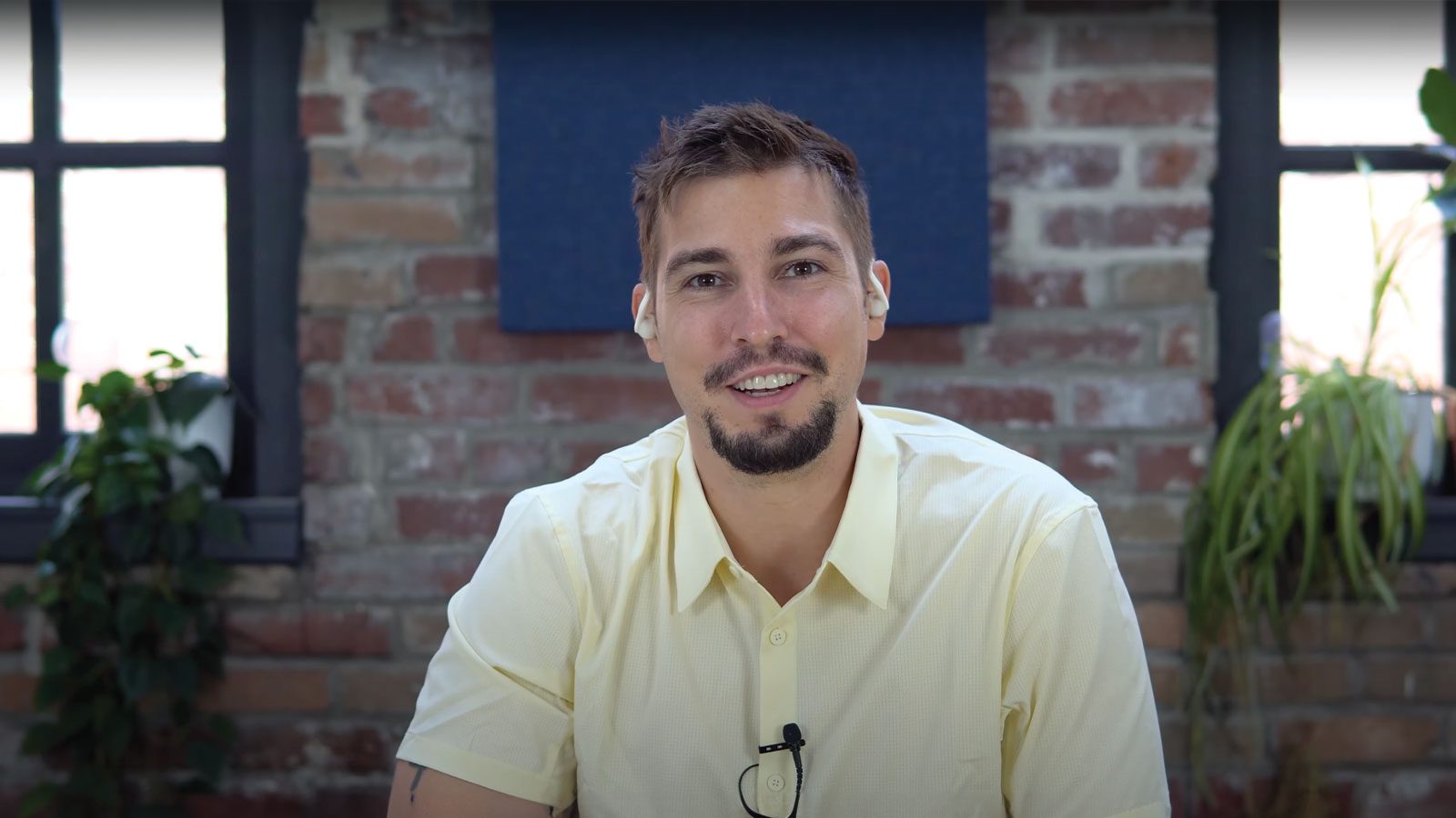 there is a man sitting at a table with a laptop and headphones on