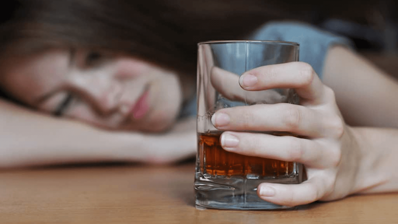 there is a woman that is holding a glass of alcohol