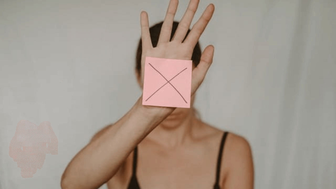 someone is holding a pink piece of paper in front of their face