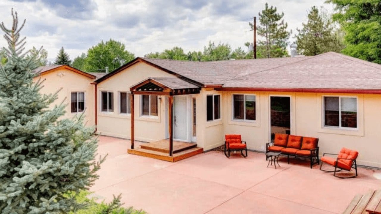 a close up of a house with a patio and chairs