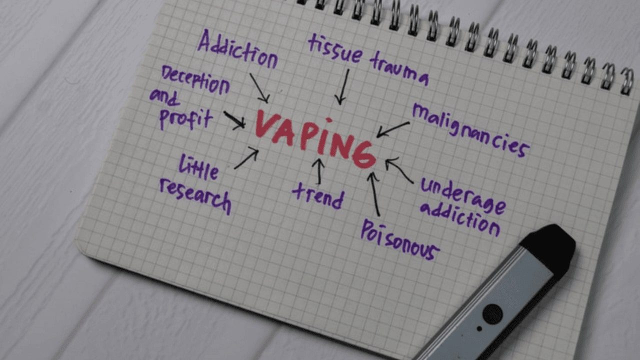a close up of a notepad with a pen and a drawing of vaping
