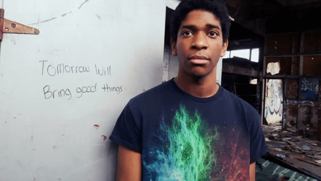 arafed man standing in front of a wall with graffiti on it