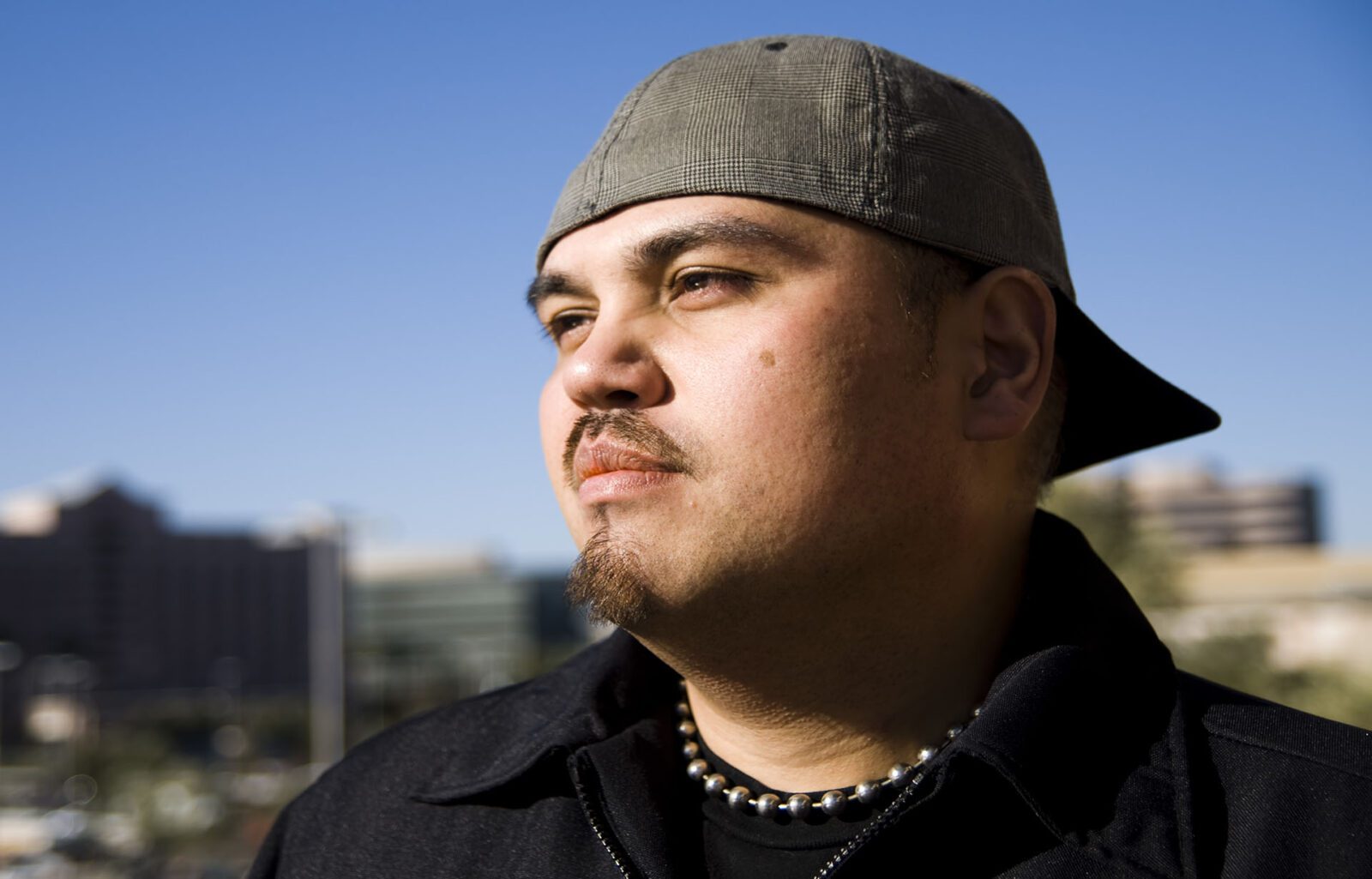 there is a man with a hat on looking off into the distance