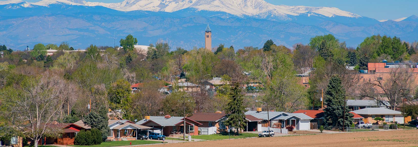 mountains in the distance with houses and a church in the foreground