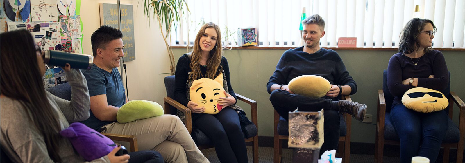 several people sitting in chairs with smiley faces on them