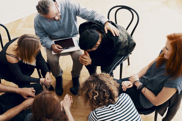 several people sitting around a table with a laptop computer