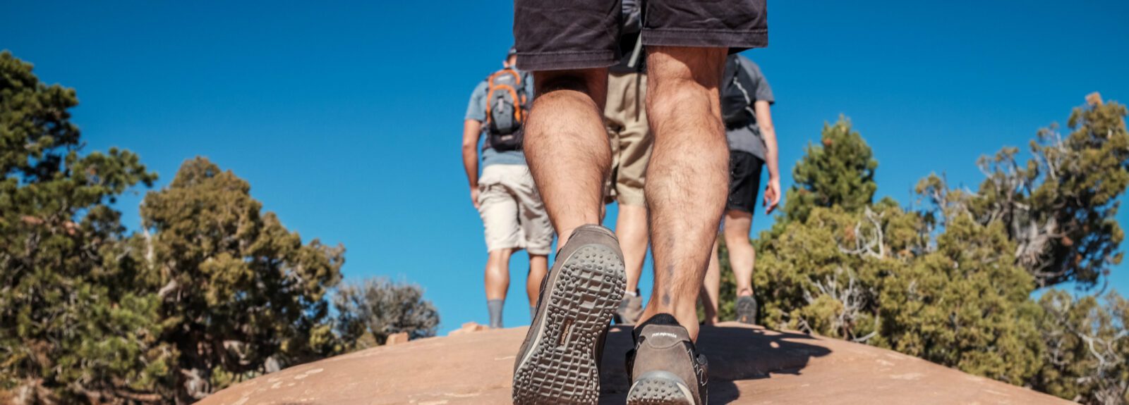 there are people walking on a rock with their feet on the ground