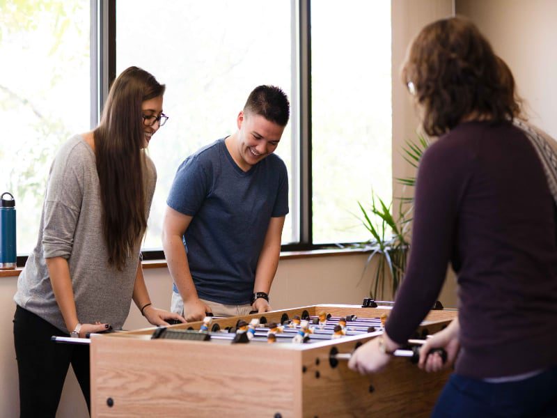 three people playing a game of foo foo foo in a room