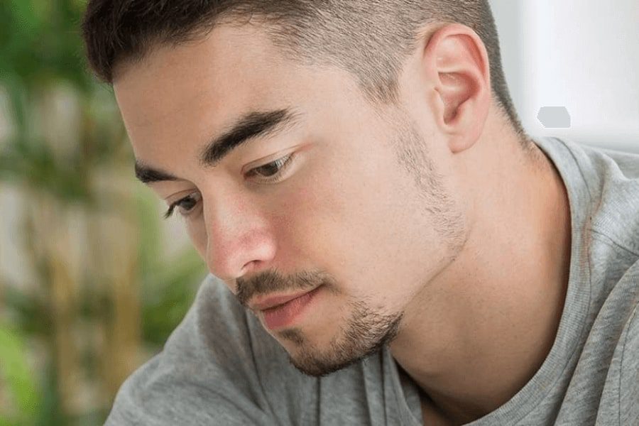 A male young adult looking down