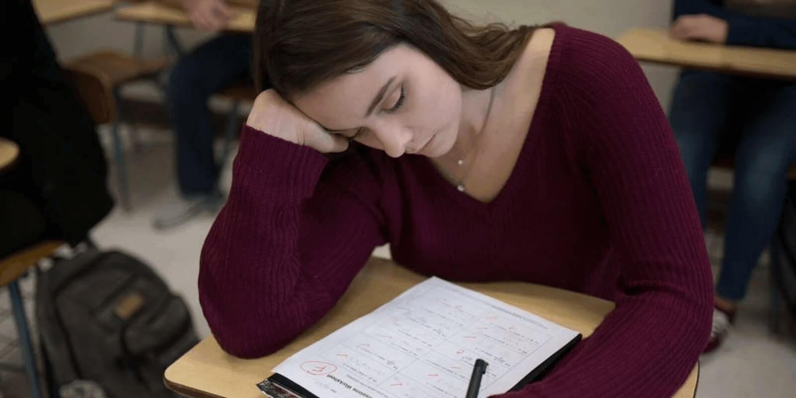 arafed woman sitting at a desk with a pen and paper