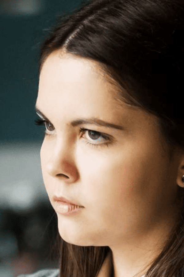 there is a woman that is looking out the window with a cell phone