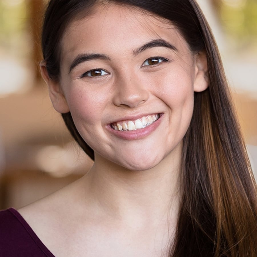 smiling woman with long brown hair and a purple shirt