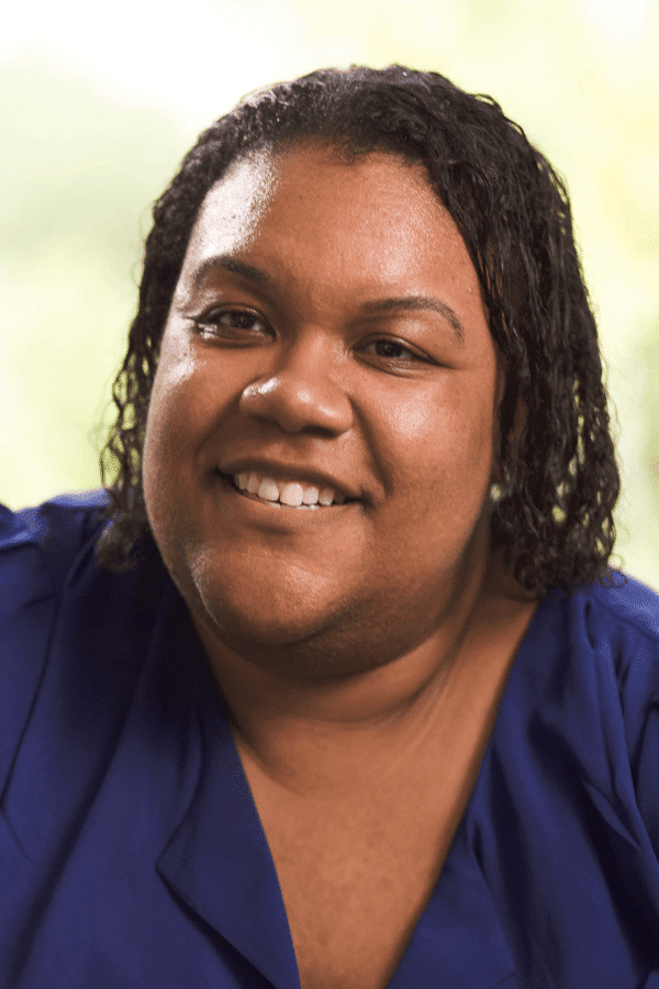 smiling woman with a blue shirt and a white shirt