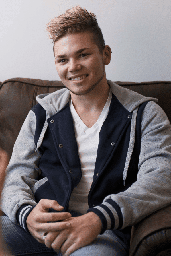 there is a man sitting on a couch with a remote in his hand