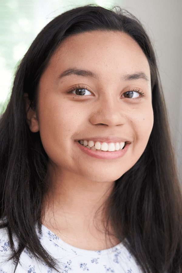 a close up of a woman with long hair smiling at the camera