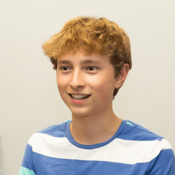 there is a young boy smiling and holding a wii controller