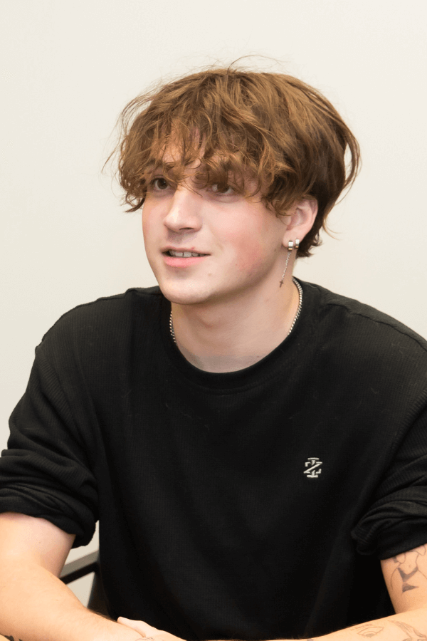 there is a young man sitting at a table with a remote