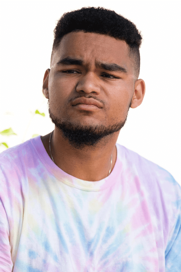 arafed man with a tie dye shirt and a cell phone