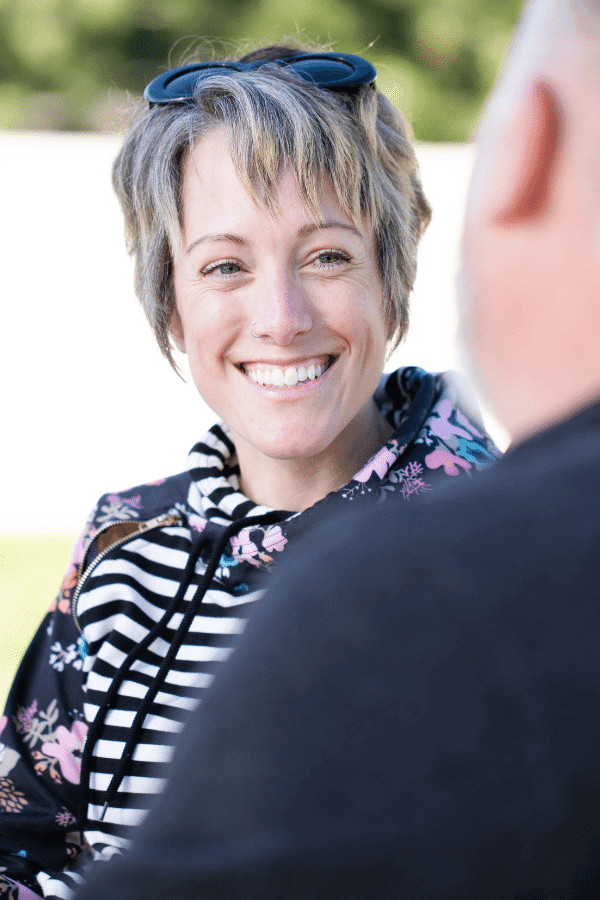 smiling woman with sunglasses on her head and a man in a black shirt