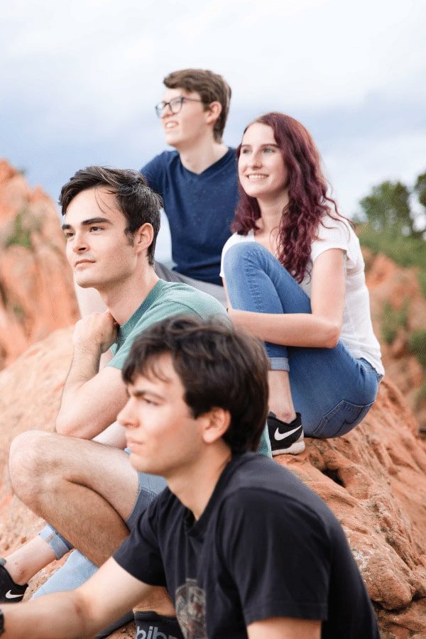 arafed young man and woman sitting on a rock with a boy