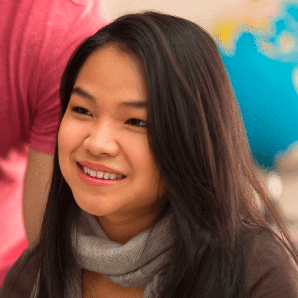 smiling woman with long black hair and scarf holding a cell phone