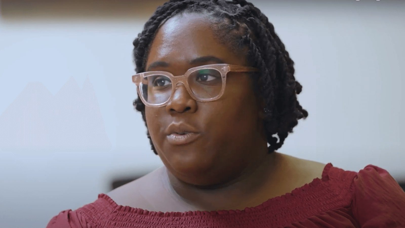 there is a woman with glasses and a red top sitting down