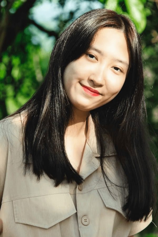 a close up of a woman with long hair and a smile
