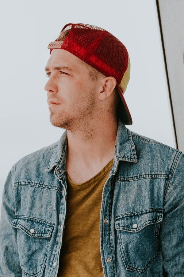 a close up of a man wearing a hat and a jacket