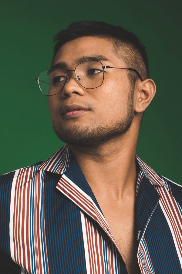 a close up of a man wearing glasses and a striped shirt